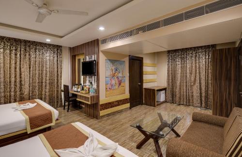 a hotel room with a bed and a tv at The Royal Melange Beacon in Ajmer