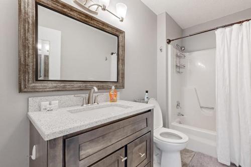 a bathroom with a sink and a toilet and a mirror at Kingswood 6E in Quechee