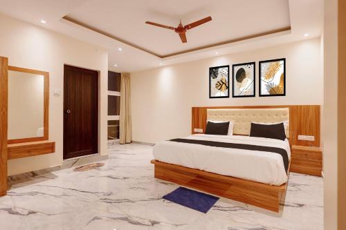 a bedroom with a large bed and a mirror at Hotel O Kamala Resort in Bhubaneshwar