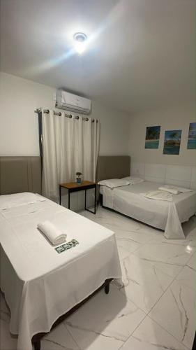 a room with two beds and a heater on the wall at Pousada Brilho dos Lençóis in Barreirinhas