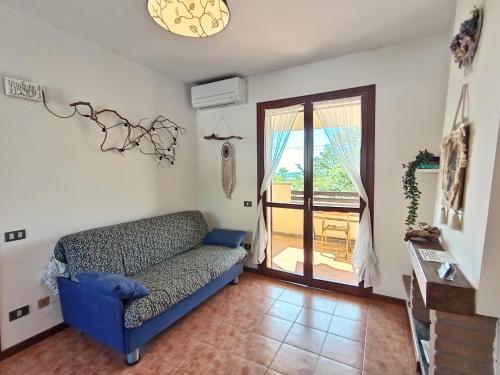 a living room with a couch and a sliding glass door at Casa Oscar in Catabbio