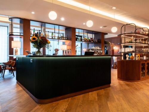 a bar with a black counter in a room at Mercure Villefranche-sur-Saône in Villefranche-sur-Saône