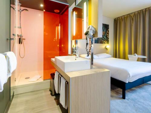 a bathroom with a bed a sink and a shower at ibis Styles Troyes Centre in Troyes