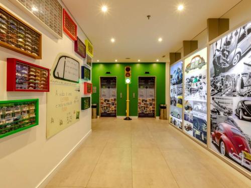 a hallway of a car shop with green walls at Ibis Styles Balneário Camboriú - 1 Quadra do Mar in Balneário Camboriú