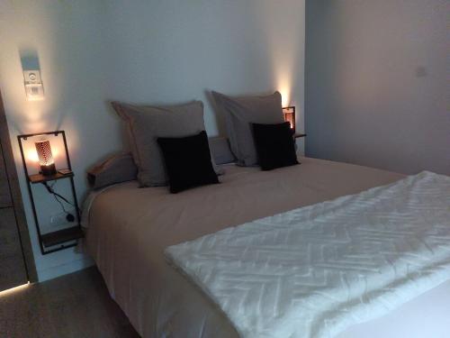 a bedroom with a large white bed with pillows at DUPLEX 3eme étage in Le Vigan