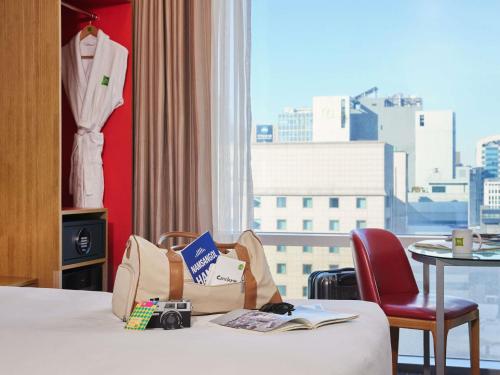 a hotel room with a bed with a camera on it at ibis Styles Ambassador Seoul Myeong-dong in Seoul