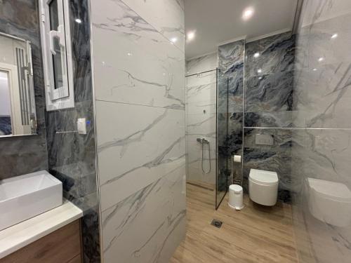 a bathroom with a shower and a sink and a toilet at The Onyx Residence in Loutraki