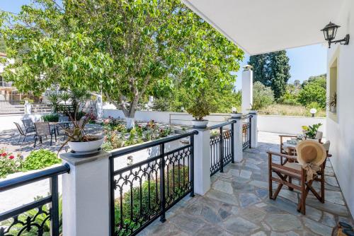 an outdoor patio with a fence and trees at Casa Mia Skopelos - Spacious 3-Bedroom House near Stafylos Beach in Skopelos Town