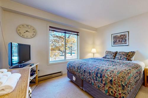 a bedroom with a bed and a clock on the wall at Snow Mountain Village 13A in Dover