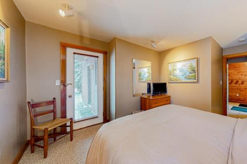 a bedroom with a bed and a chair and a window at Trail Creek 53 in Killington