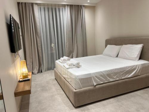 a bedroom with a large bed and a television at Piknik Suites in Dhërmi