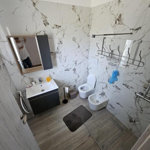 a white bathroom with a sink and a toilet at Villa Doku in Valjiosi