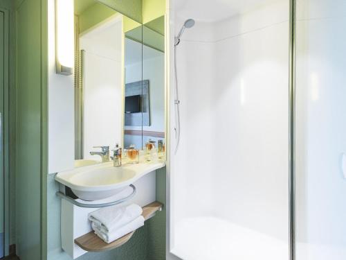 a bathroom with a sink and a mirror at Ibis budget Rouen Petit Quevilly in Le Petit-Quevilly