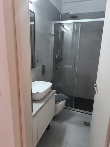 a bathroom with a toilet and a sink and a shower at Seaside Nest in Kythira