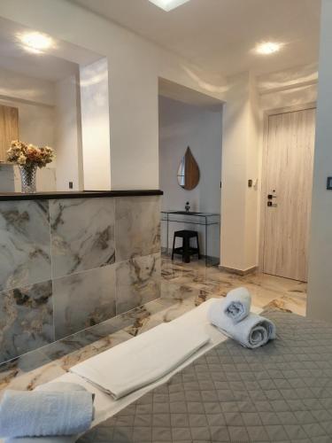 a bathroom with a tub with towels and a sink at Althea Studios & Apartments in Hanioti