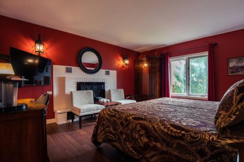 a red bedroom with a bed and a fireplace at Butterfly Manor in Niagara Falls