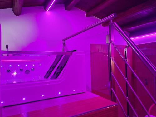 a purple room with a bath tub with stairs at Gredò Home & SPA in Gratteri