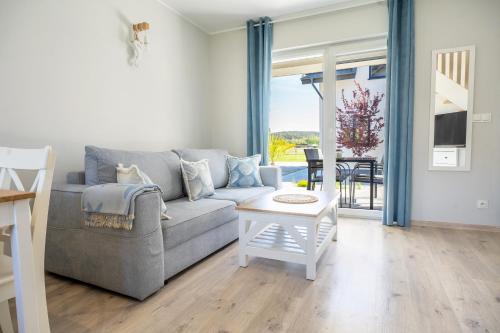 a living room with a couch and a table at Apartamenty Lagos in Karwia