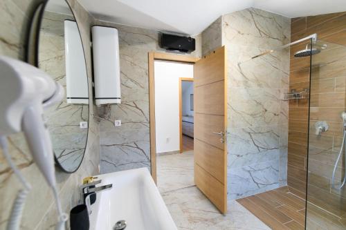 un bagno con lavandino e doccia di Vila Magdalena a Trebinje