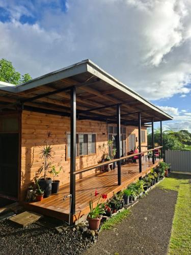 a wooden cabin with plants on the deck at Luna Studio in Apia