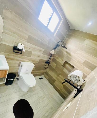 a bathroom with a toilet and a sink and a window at Villa renacer in Baní