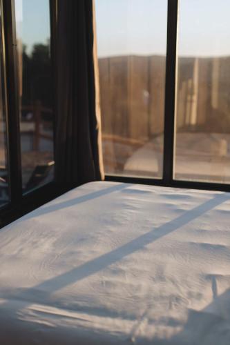 a bed in a room with two windows at Hidden Abode in Orderville