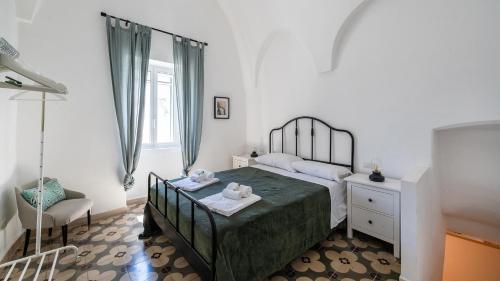 a small bedroom with a bed and a chair at Casa Superga by Rentbeat in Cisternino
