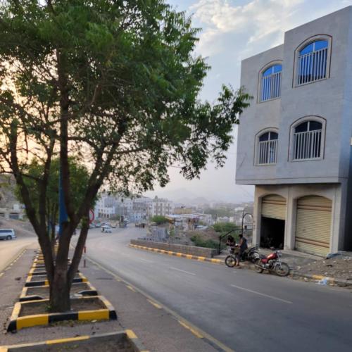 two motorcycles parked on a street next to a building at ألعز in Qaḩāzah