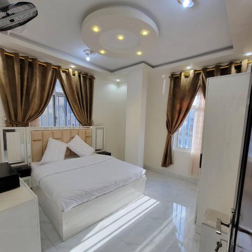 a bedroom with a white bed and some windows at ألعز in Qaḩāzah