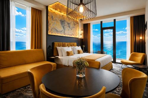 a hotel room with a bed and a table at Miramare Magnetic Beach Hotel in Kobuleti