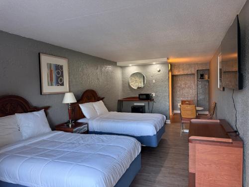 a hotel room with two beds and a desk at Ocean 12 Beach Hotel in Myrtle Beach