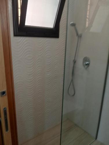 a shower with a glass door and a window at Un Studio haut standing à Monastir in Monastir