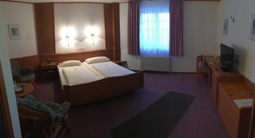 a hotel room with a bed and a television at Hotel Zur Buche in Bockhorn