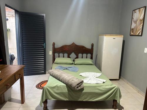 a bedroom with a bed and a refrigerator at Apto aconchegante 02 in Aquidauana