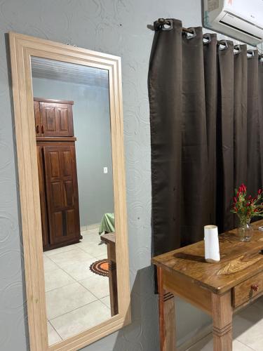 a mirror with a black curtain next to a table at Apto aconchegante 02 in Aquidauana