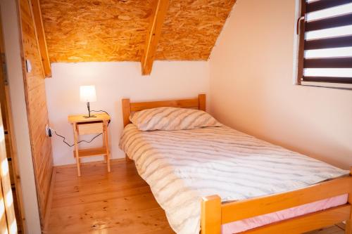a small bedroom with a bed and a table at Vikendica Vinogradski Mir, Jacuzzi and Vineyard View in Bačinci