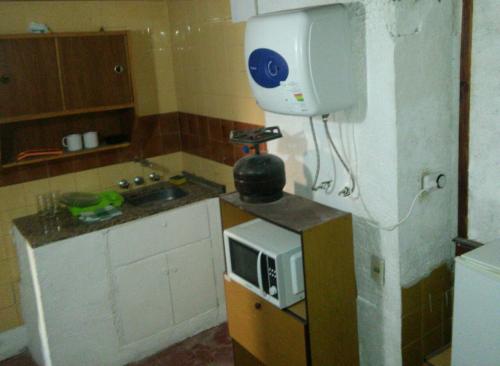 a small kitchen with a microwave on a counter at Piria Apartamento Bahiamar in Piriápolis