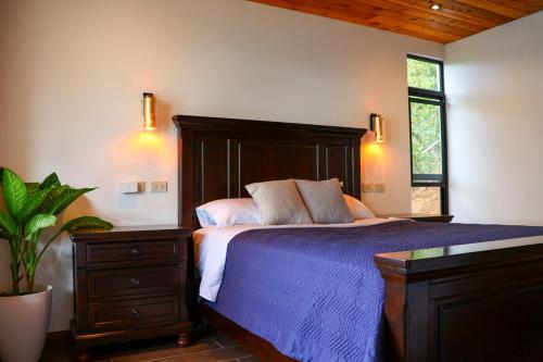 a bedroom with a bed with a blue comforter at Jardín de Janaab' in San Antonio Palopó