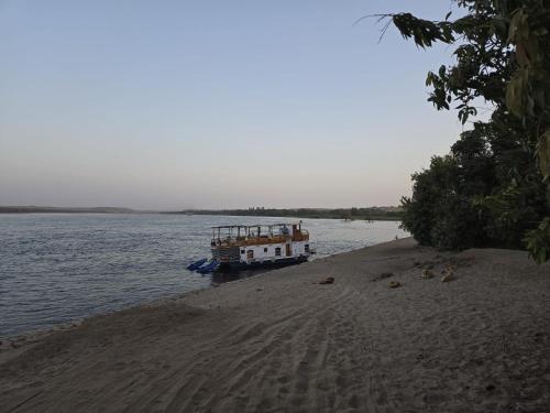 a boat is docked on the shore of a river at Houseboat Hotel and Nile Cruises Zainoba in Aswan