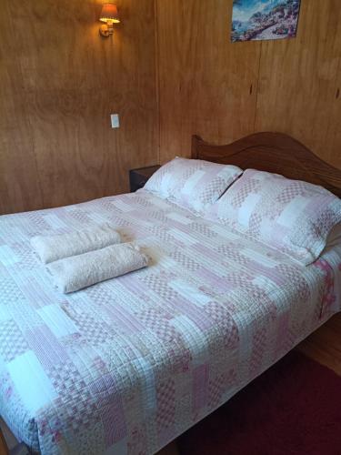 a bed with white sheets and pillows on it at Cabañas Cadiz Valdivia in Valdivia