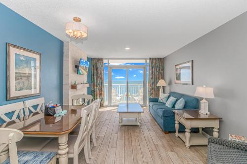 a living room with a blue couch and a table at Atlantica 1055 in Myrtle Beach
