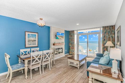 a living room with blue walls and a table and a couch at Atlantica 1055 in Myrtle Beach