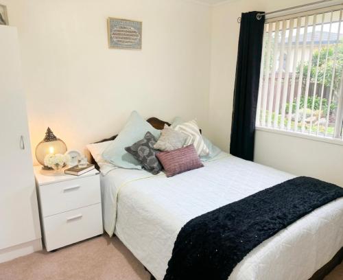 a bedroom with a bed and a window at Private 2-Bedroom Suite in 3-Bedroom House in Auckland