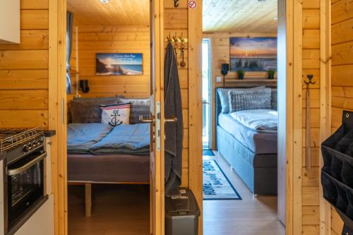 a small room with two beds in a cabin at Haus am See Thermal Bad Saarow in Bad Saarow