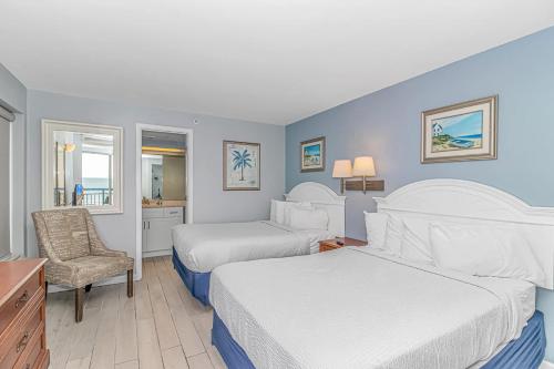 a hotel room with two beds and a chair at Boardwalk 439 & 440 in Myrtle Beach