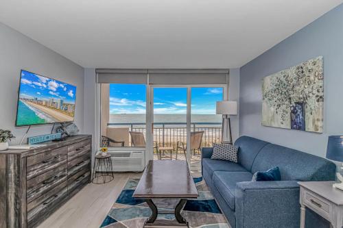 a living room with a blue couch and a tv at Boardwalk 439 & 440 in Myrtle Beach