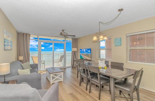 a dining room and living room with a table and chairs at Atlantica 757 in Myrtle Beach