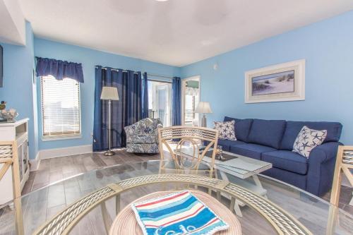 a living room with blue walls and a blue couch at The Palace 1513 in Myrtle Beach
