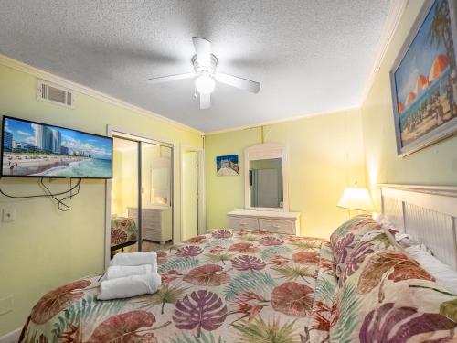 a bedroom with a bed and a ceiling fan at A Place at the Beach 406 in Myrtle Beach