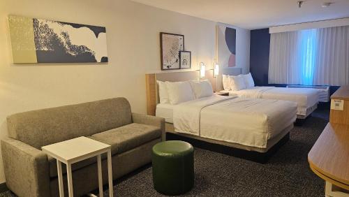 a hotel room with a bed and a couch at Spark by Hilton Tempe Phoenix Airport in Tempe
